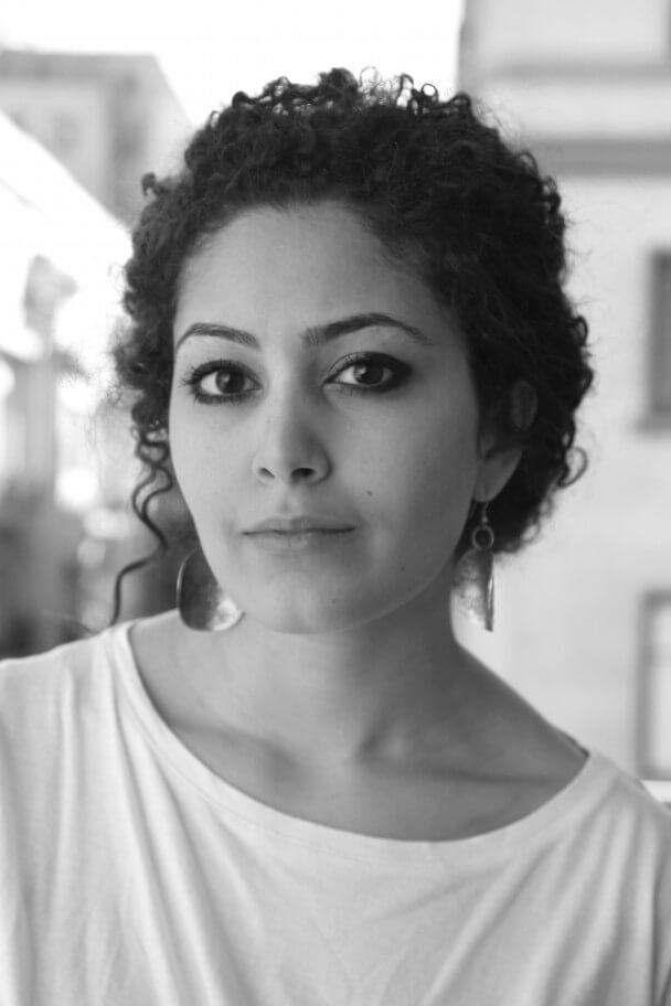 Hanan Abdalla looks directly at the camera. Black and white portrait.