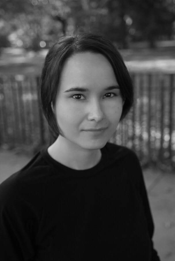 Christina D. King looks at the camera. Black and white portrait.
