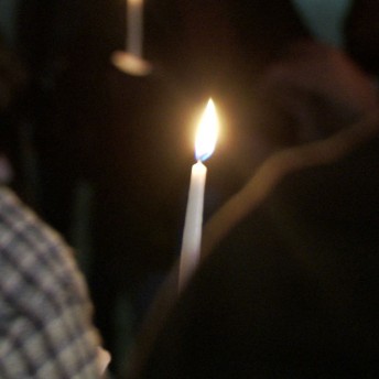 Still from Valentine Road. A candlelight ceremony with a camera angle over the back of the shoulder of a participant.