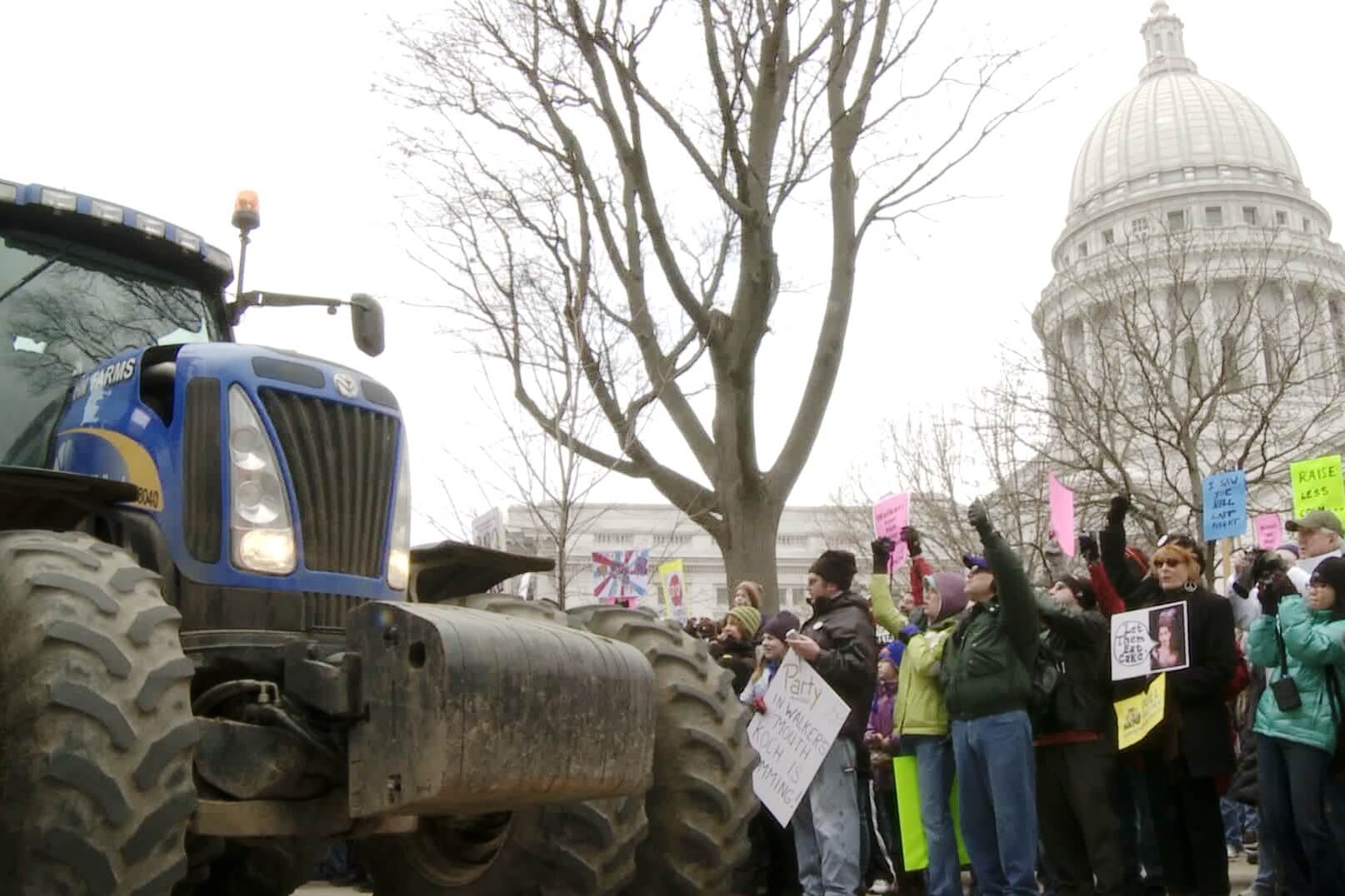 People in a demonstration in DC. They are standing in front of a tractor.
