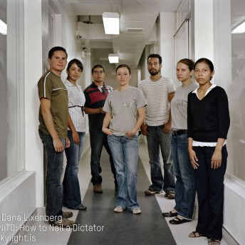 Still from Granito. Group photo of 7 men and women staring straight ahead, unsmiling. The photo is taken in a white hallway, with overhead fluorescenet lights and airducts. An sign on the wall reads: "Cuarto Jefe de Genética Forense" (translation in English: Room of Head of Genetic Forensics). Photo credit is listed on the bottom left of the image.