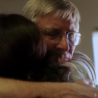 Still of After Tiller. Close up of two people hugging. A man with white hair and glasses and a woman with dark hair.
