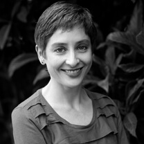 Gabriela Quirós looking directly at the camera. She has short hair and is wearing a long-sleeved top. Portrait in black and white.