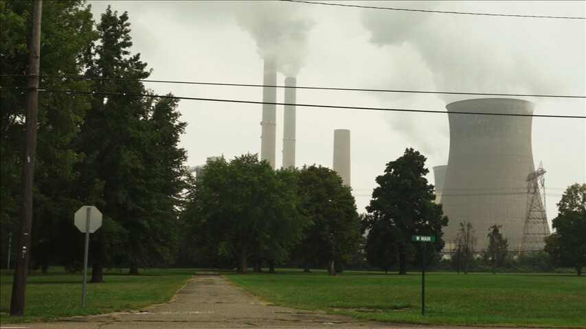 A power plant behind some trees.