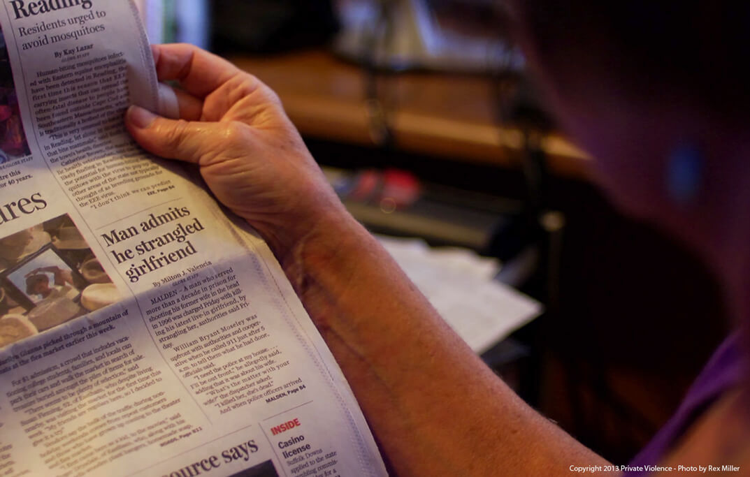 Still from Private Violence. A person's hand is holding the edge of a newspaper, isolating an article titled "Man admits he strangled girlfriend".