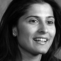 Sharmeen Obaid-Chinoy looks away from the camera, with her mouth semi-open. Portrait in black and white.