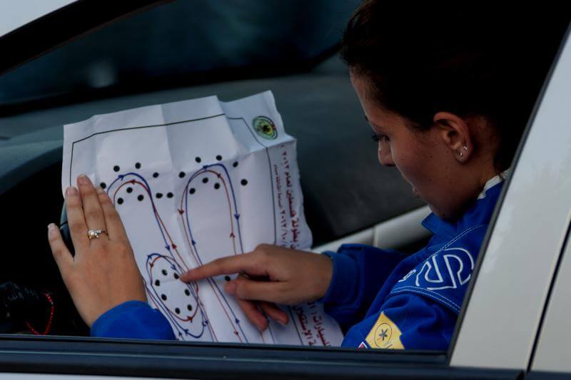 A race car driver examines a map of a race course.