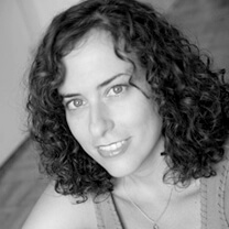 Ilana Trachtman smiles directly at the camera. Black and white portrait.
