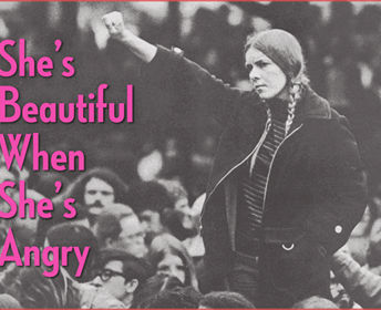 Black and white archival photography that centers a young woman raising her right fist to the air. She is surrounded by people. To the left it can be read in hot pink typography: "She's beautiful when she's angry".