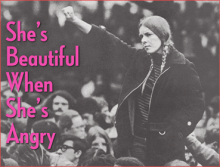 Black and white archival photography that centers a young woman raising her right fist to the air. She is surrounded by people. To the left it can be read in hot pink typography: "She's beautiful when she's angry".