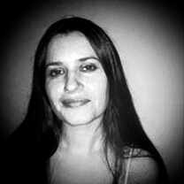Melanie Shatzky looks directly at the camera. Portrait in black and white.