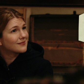 Lily Rabe as Mona Peek is looking away at the camera. Color photograph.