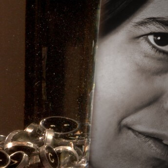 Close-up to a photo with Susan Sontag's face, to the left, there is a jar with circled types from a typography machine.