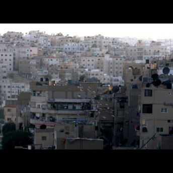 Still from Between Earth & Sky. A full shot of a crowded urban development.