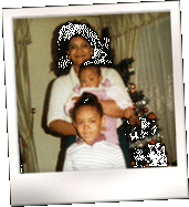 Polaroid of a woman with a baby in her arms, a small child standing in front of her. There is a Christmas tree behind them.