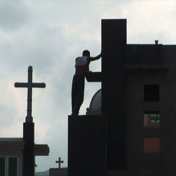 A man is standing on the roof of a grave.
