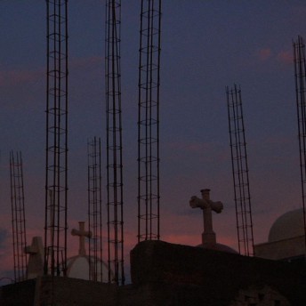 Construction structures in a cemetery during sunset.