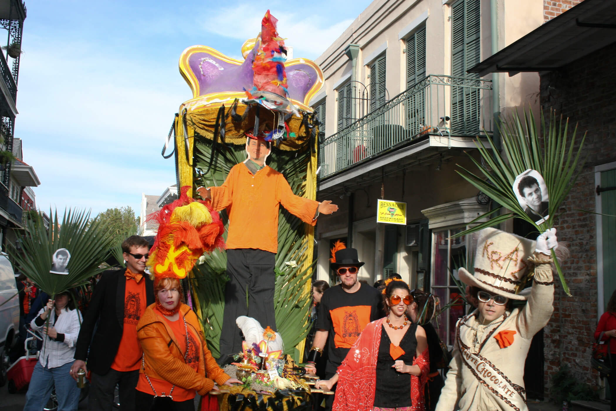 Still from My Louisiana Love. A few people wearing hats carry a parade float down a street.
