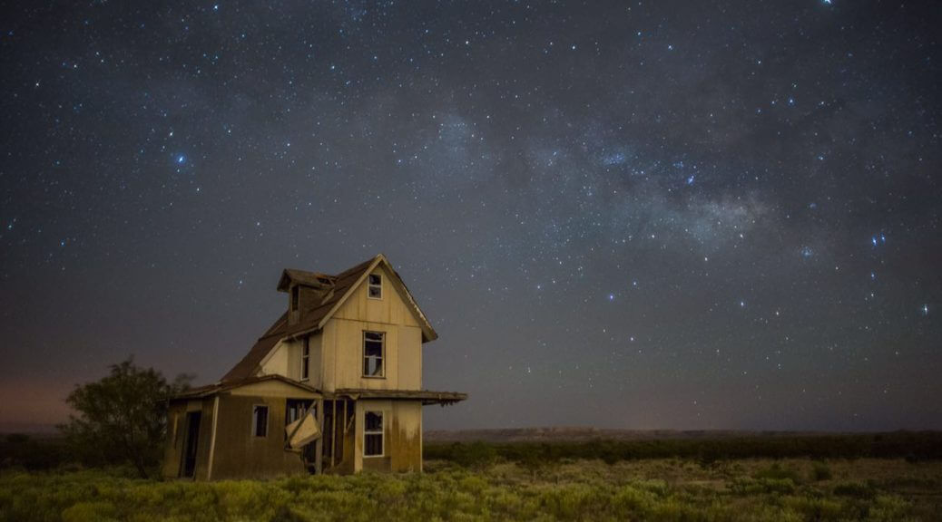 A still from The Guardian of Memory. A house sits off to the side on a grassy plain. It is night time and the sky is filled with stars and hues of blues and purples.