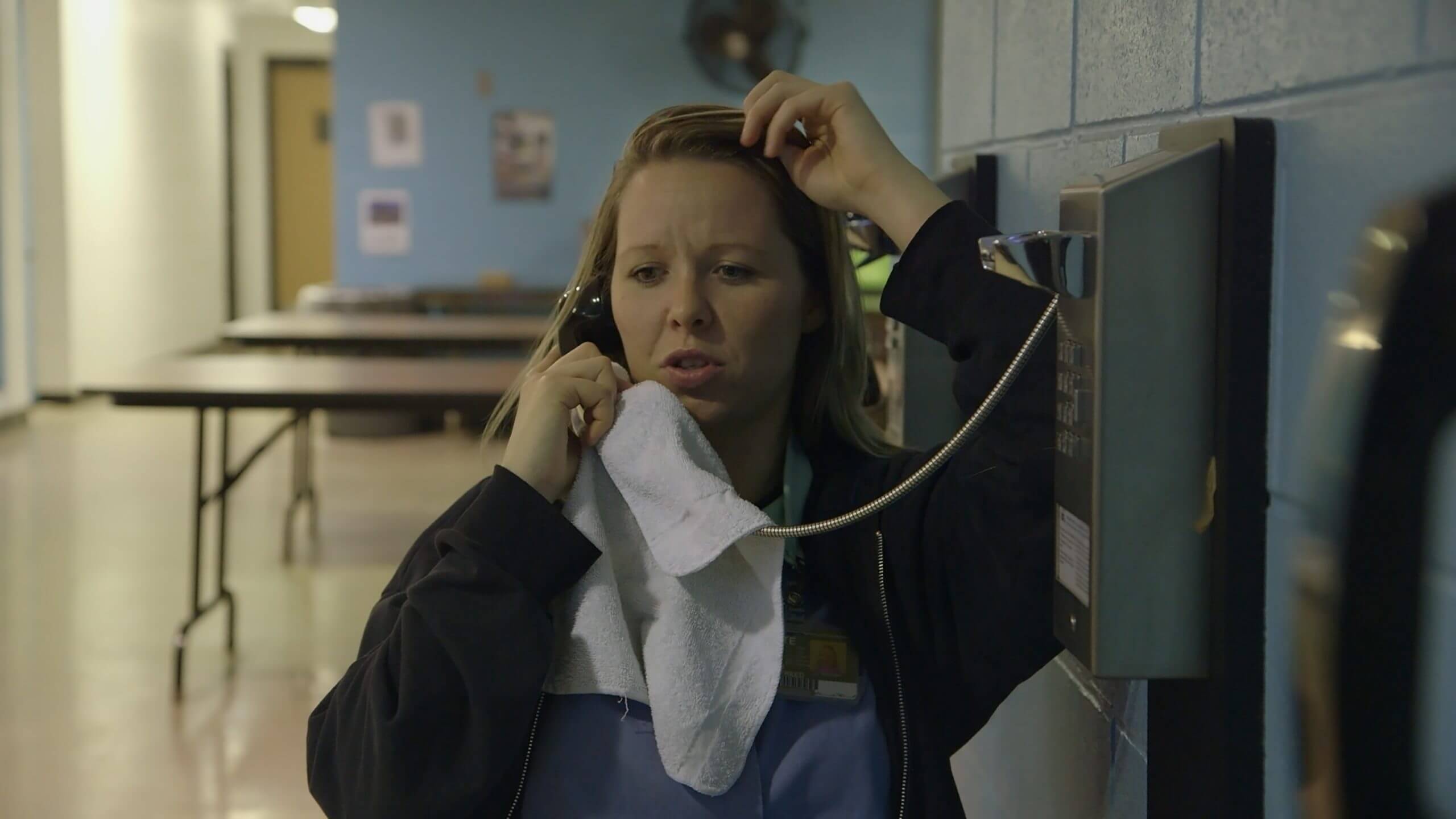 Still from Apart. Amanda is calling her son from prison.