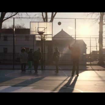 Young people playing on a basketball court.