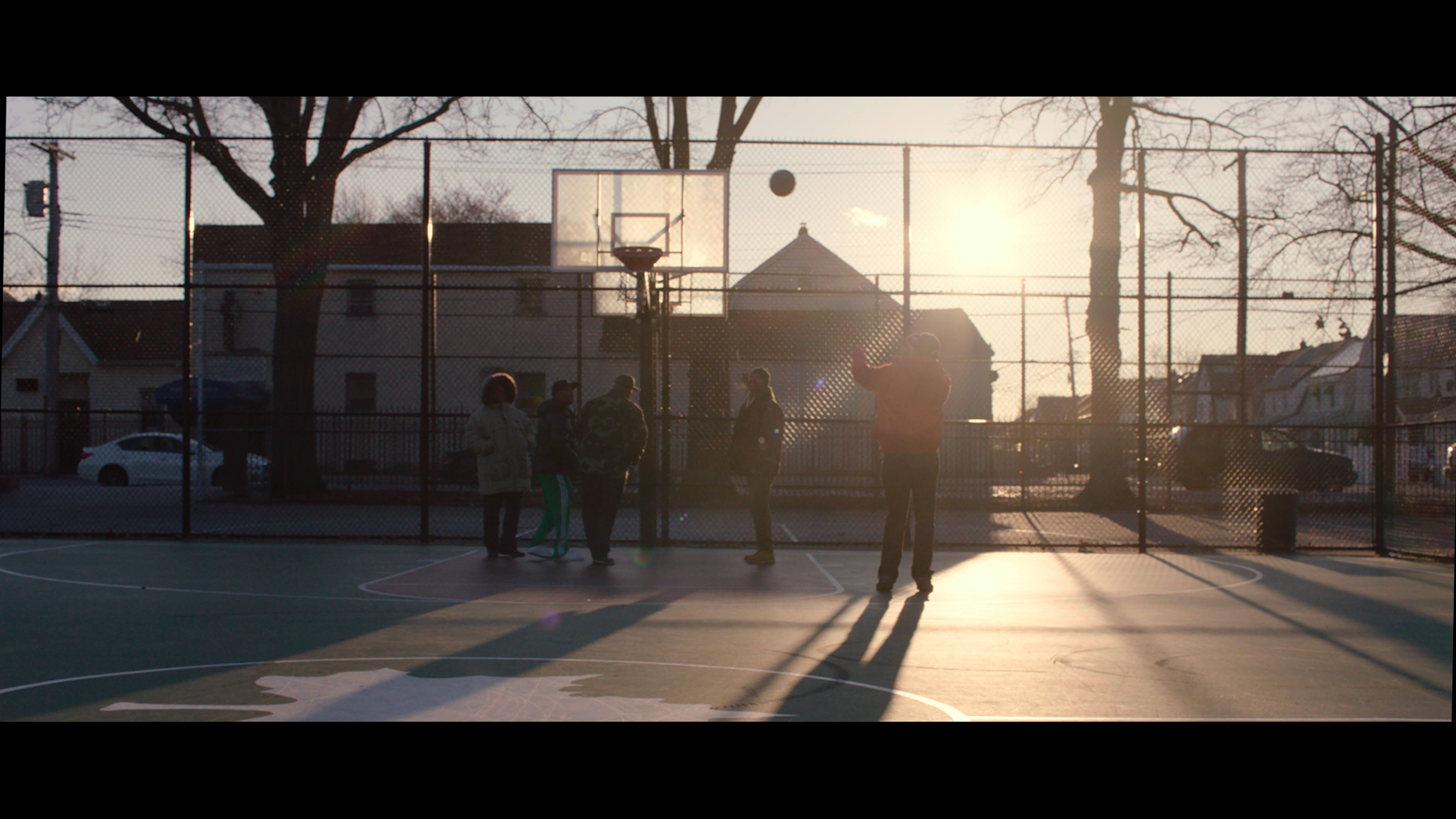 Young people playing on a basketball court.