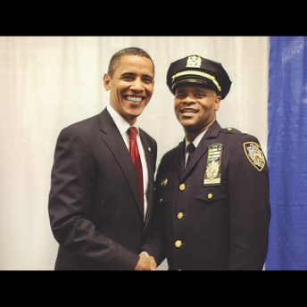 Barack Obama holding the hand of a police officer.
