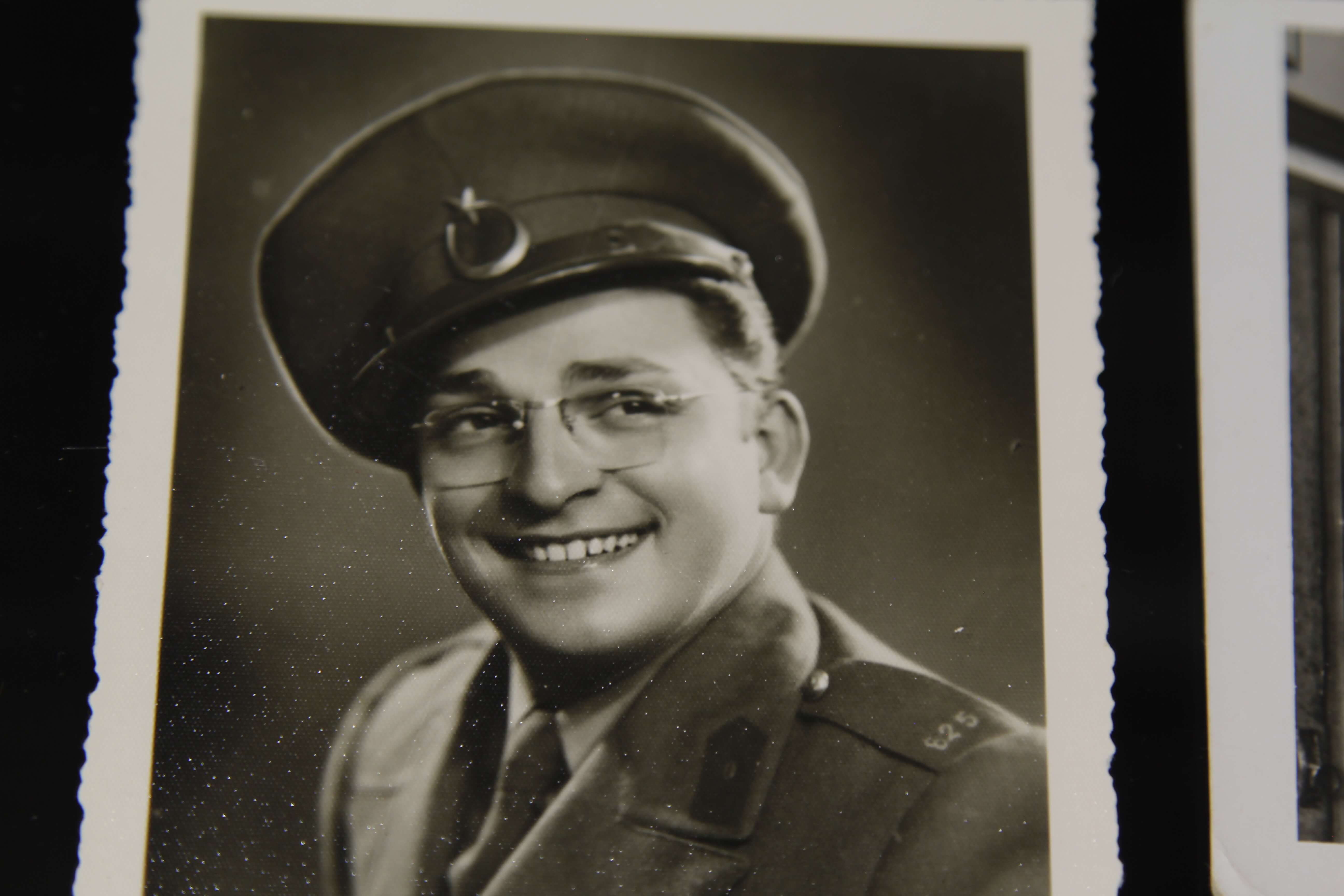 Still from A Prince from Outer Space: Zeki Muren. An old, sepia-toned, photograph of a man wearing glasses and a military uniform, he is smiling and looking off-camera.