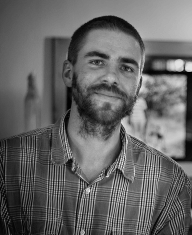 Chris King looks directly at the camera. Portrait in black and white.
