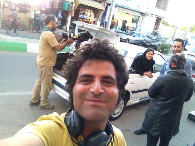Selfie photo of Mohammad Reza, and Sara Khaki in the background peeking out from a car window.