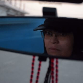 Rear view mirror reflection of a woman.