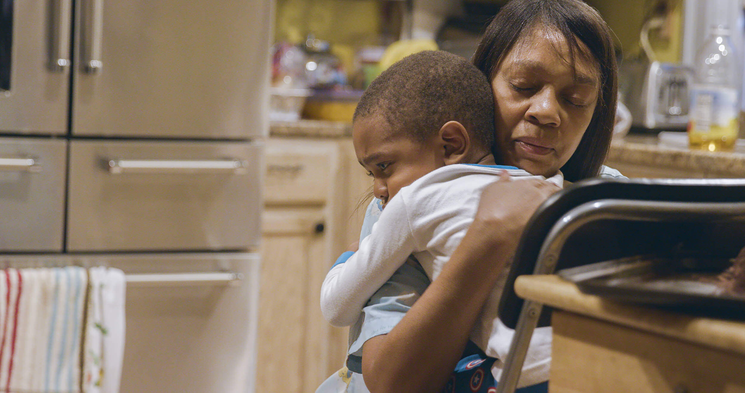 Still from Through the Night. A woman hugs an infant.