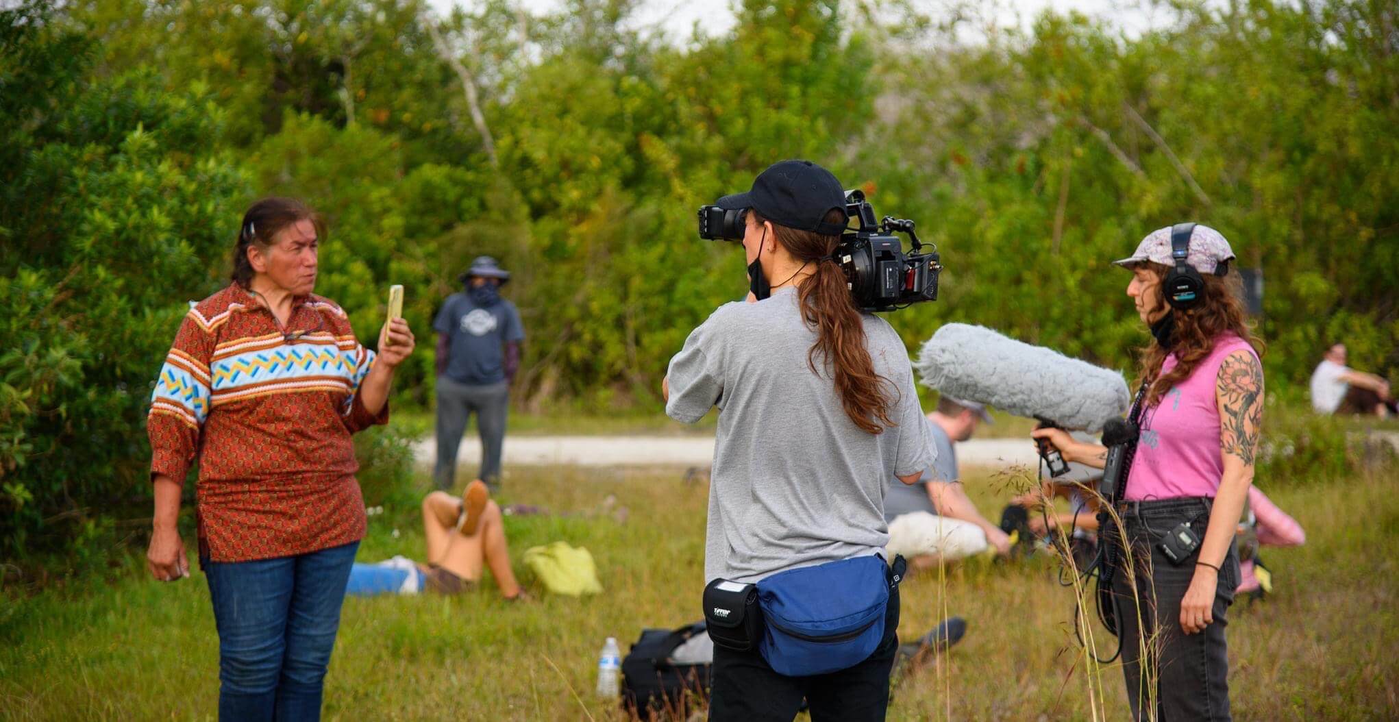 Jesse and Sasha document Betty during an action she is leading in the Big Cypress in an open green field