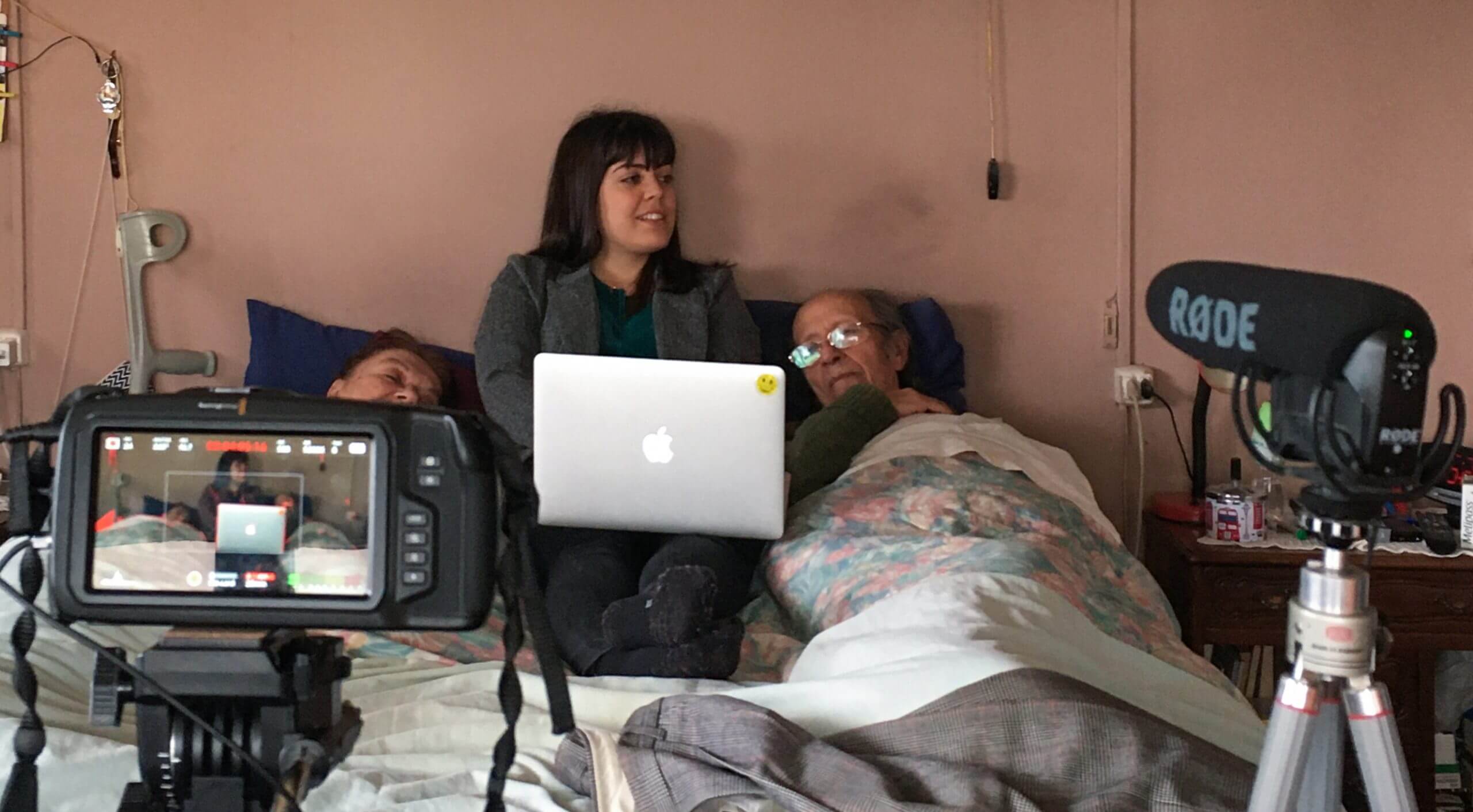 Director Gabriela Pena and her grandparents being filmed while lying in bed.