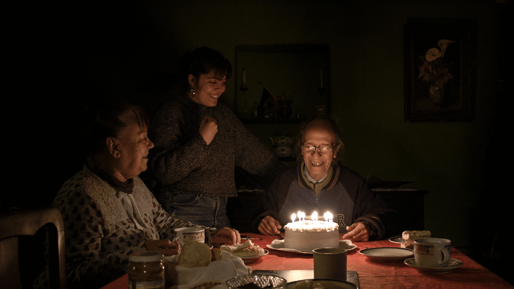 Director Gabriela Pena at her grandfather’s birthday with her grandmother and a cake with candles.