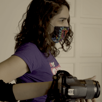 Director Indira Cato wearing an "Olimpia Law" t-shirt and a face mask while filming.