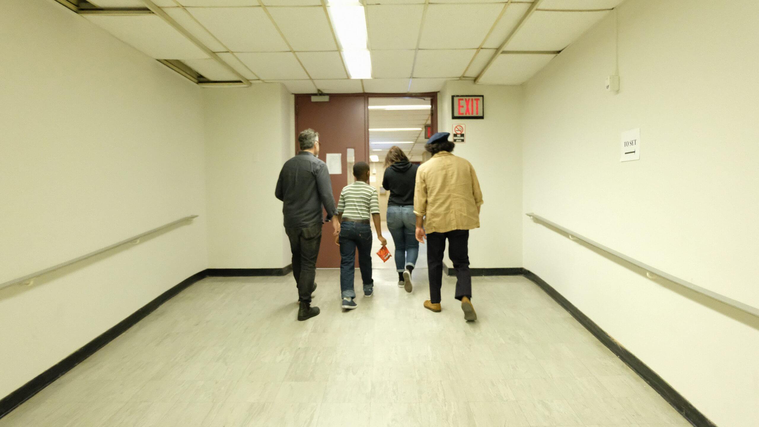 Producer Toby Gerber, Director Emma Francis-Snyder, and two actors walking in a hallway
