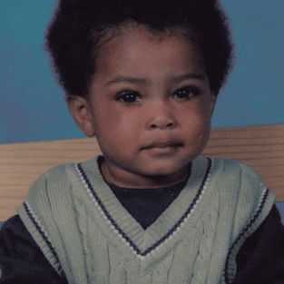 Still from Look at Me. XXXTENTACION at age 1 looks into the camera with a slight smile, against a blue and tan background