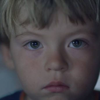 A young boy's face in an extreme close-up looks directly at the viewer.