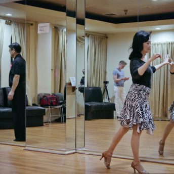 Middle Aged Asian couple at dance practice reflected in mirror