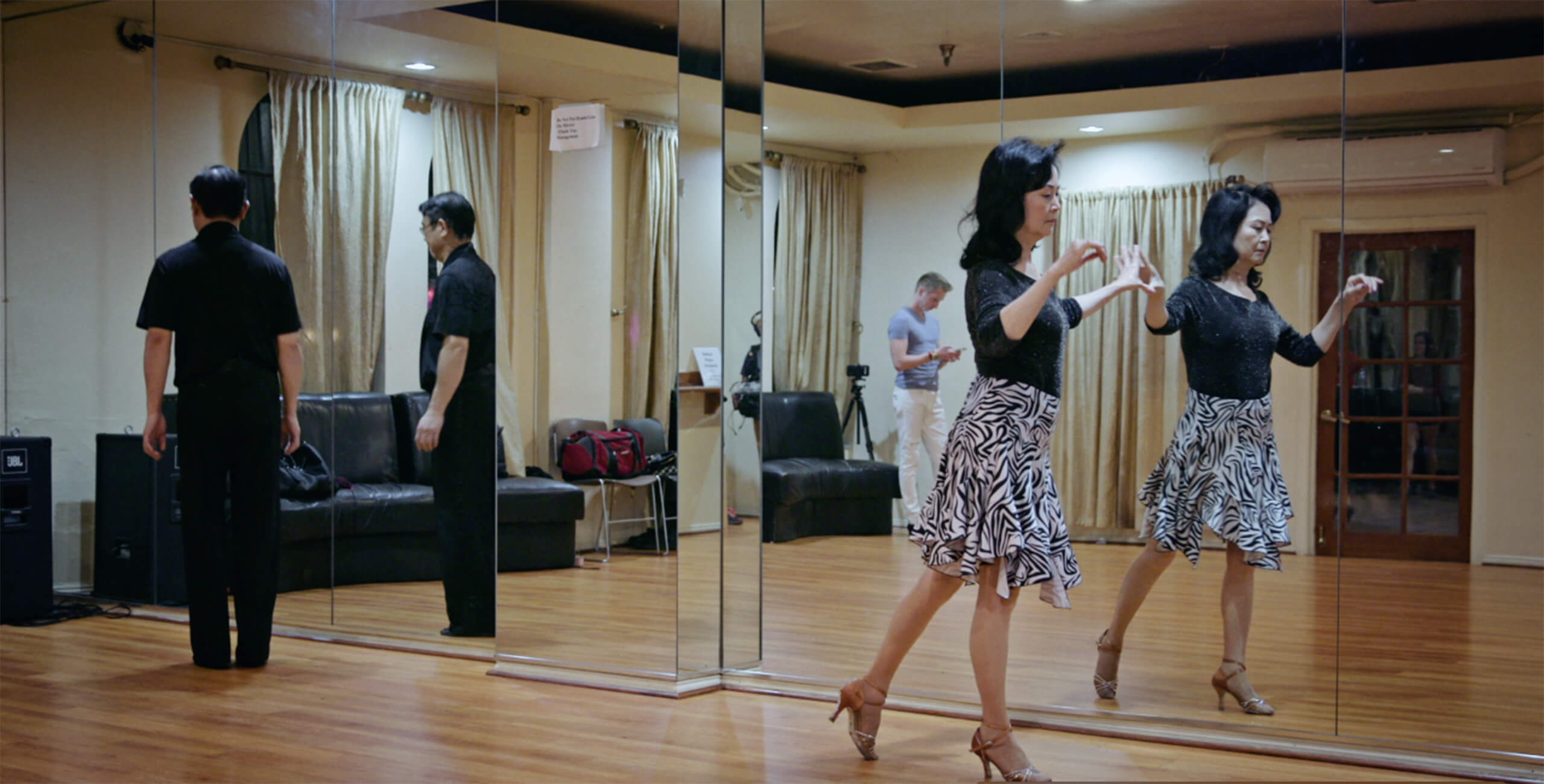Middle Aged Asian couple at dance practice reflected in mirror