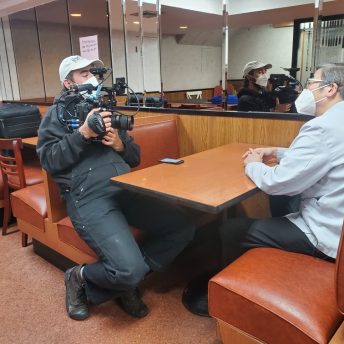 Peter Lee being interviewed on camera in his New York Chinatown restaurant Hop Kee