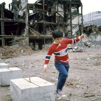 Boy with Canadians Jersey in front of demolished Chinatown buildings in Montreal circa 1980.