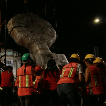 A group of women carry the sculpture that will be an anitominument in Mexico City.