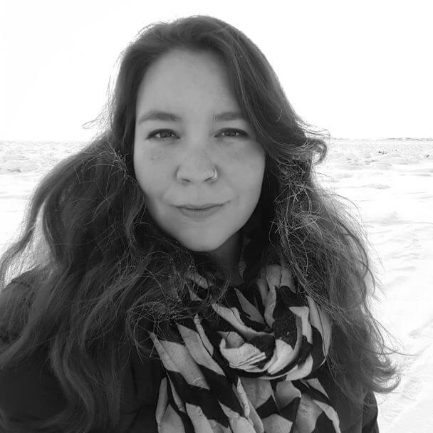 The producer of Twice Colonized, Stacey Aglok MacDonald, looking into the camera. She an Inuit woman with dark brown hair, and around 40 years of age. Black and white portrait.