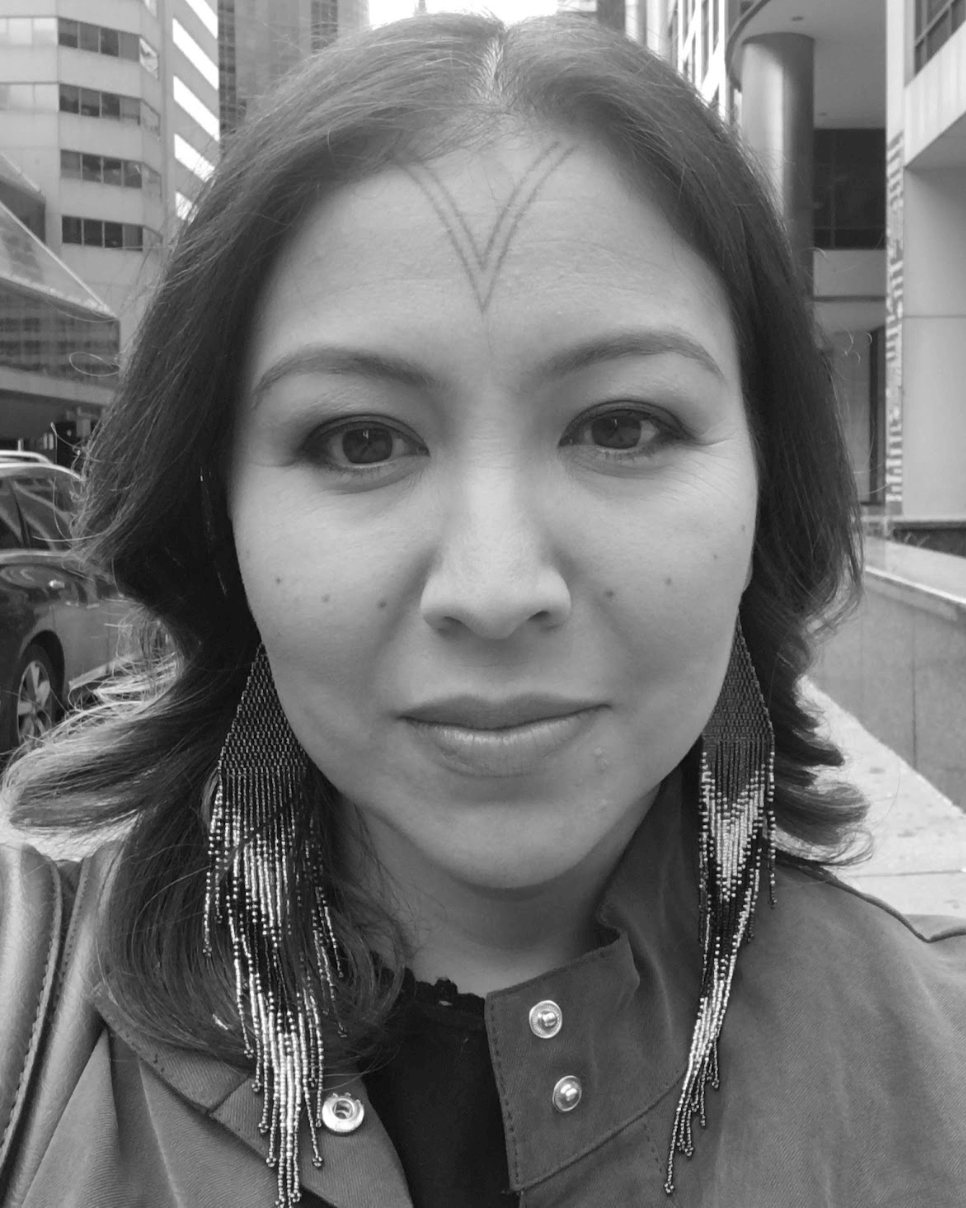 The producer of Twice Colonized, Alethea Arnaquq-Baril, looking into the camera. She an Inuit woman with black hair and facial tattoos, and around 40 years of age. Black and white portrait.