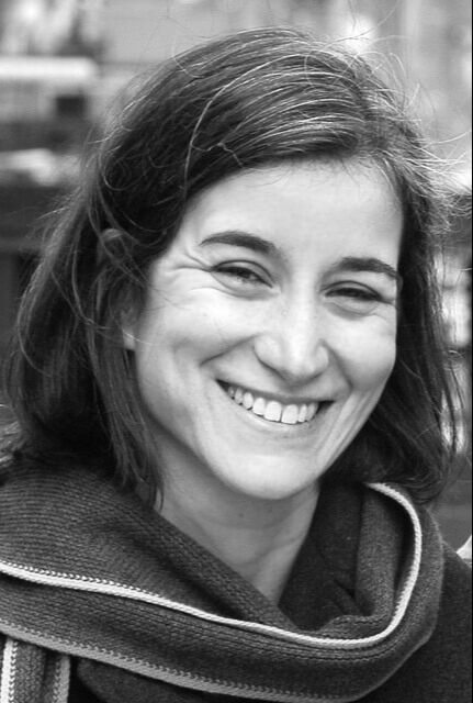 Producer Yael Melamede looking directly at camera and smiling. Black and white photo.