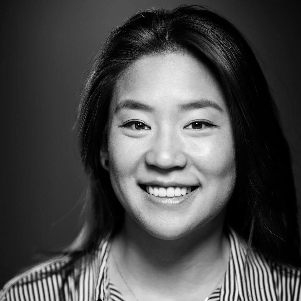 Sarah Lee looking directly at camera and smiling. Black and white photo.