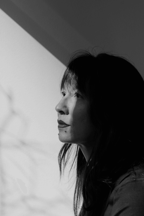 Profile portrait of Ursula Liang. She sits with shadows across her face.