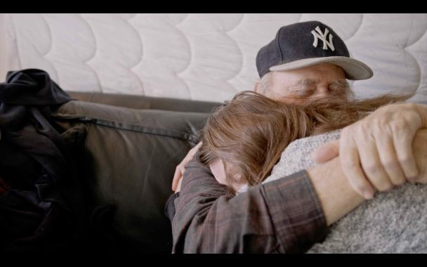 The relationship between father and daughter - the heart of the film. The first photo is a close up image of a young woman (daughter) hugging and older man (her father). It is a heartfelt hug and their eyes are both closed and arms clasped tight.
